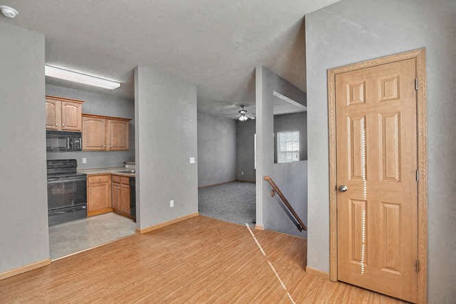 an empty living room and kitchen with a wooden door