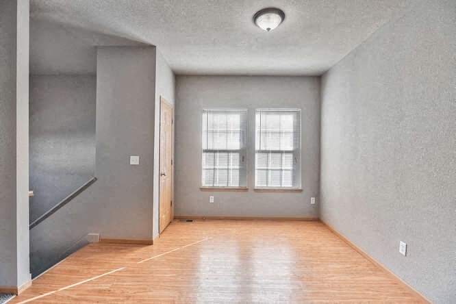 an empty room with a wood floor and a window