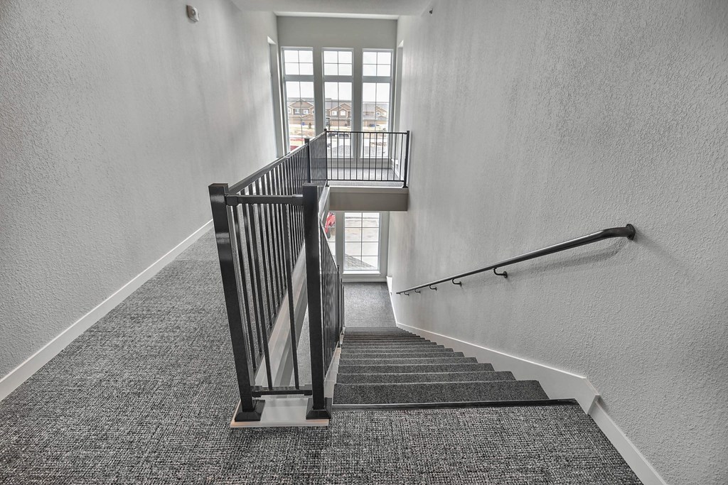 a stairwell with a metal railing and a window