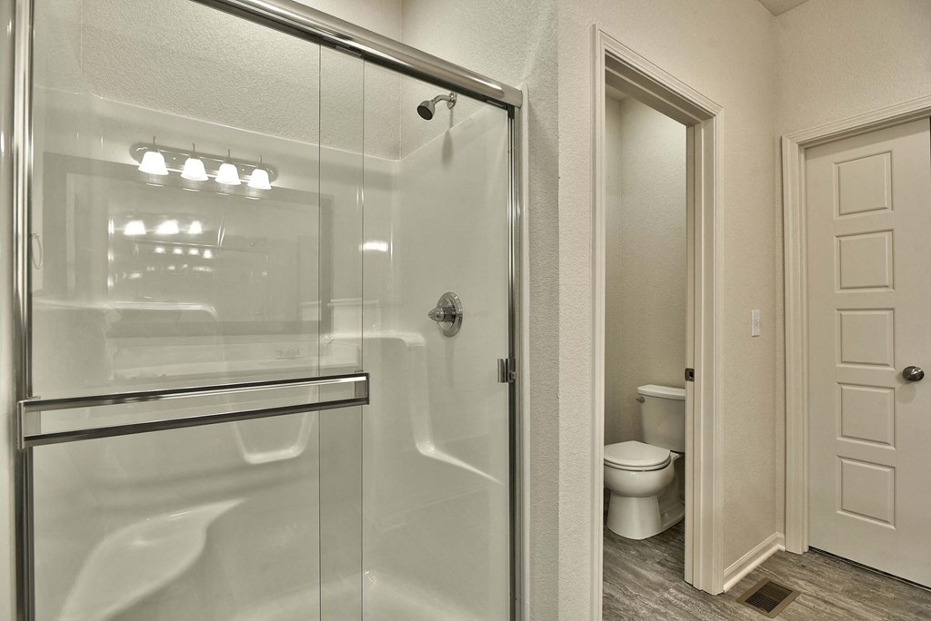 a bathroom with a glass shower door and a toilet