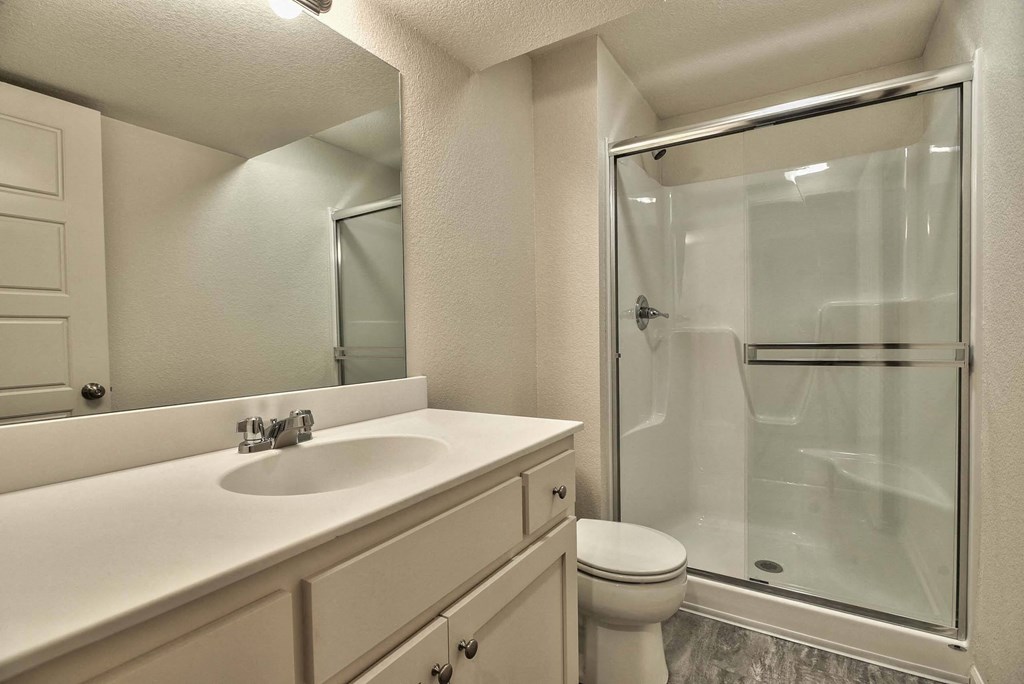 a bathroom with a shower sink and toilet