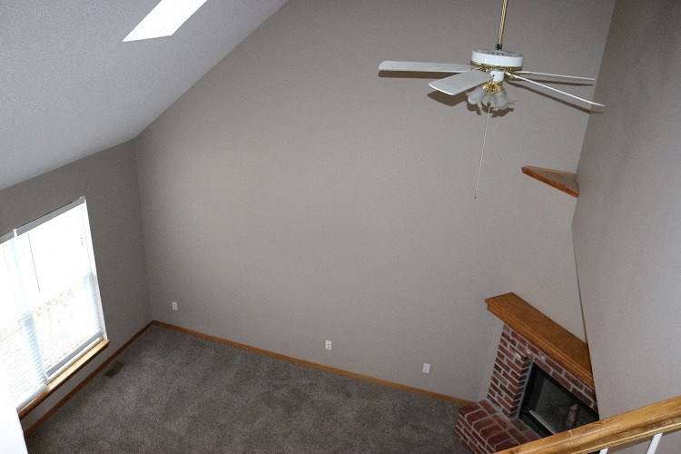 a living room with a fireplace and a ceiling fan