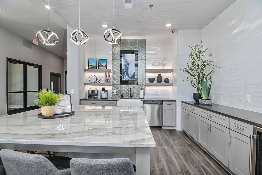 a white kitchen with a marble counter top