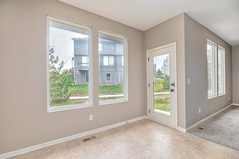a living room with three large windows and a door