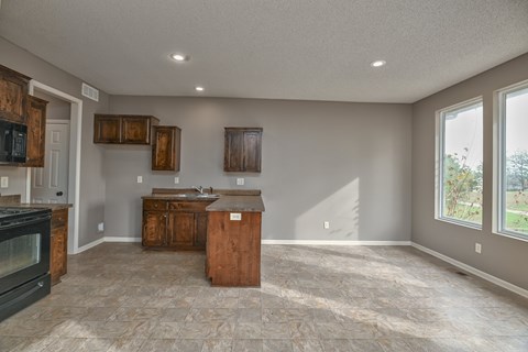A kitchen with a black oven and wooden cabinets.
