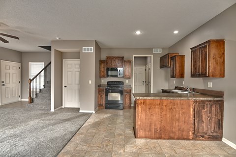 A kitchen with a copper island and a staircase in the background.