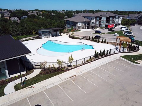 an aerial view of a swimming pool in front of a apartment building