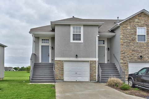 a gray house with a car parked in a driveway