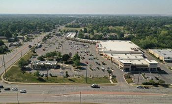 an aerial view of a parking lot with cars and buildings