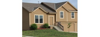 the front of a house with stairs and a yard