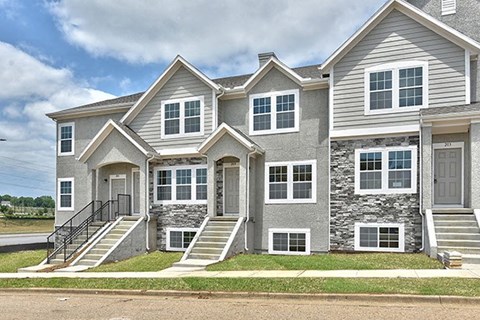 a large house with stone and gray siding