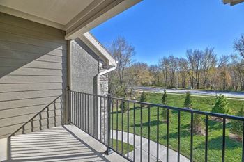 a balcony with a view of a field and trees