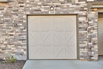 a white garage door on the side of a brick building