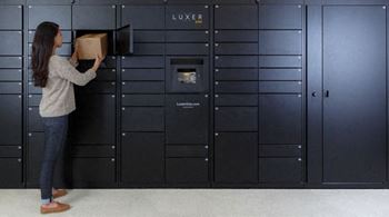 a woman is loading a box into some lockers