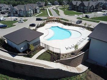 an aerial view of a swimming pool in front of a house