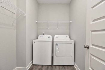 a white laundry room with two washes and a dryer