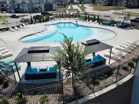 an aerial view of a swimming pool with chairs and tables