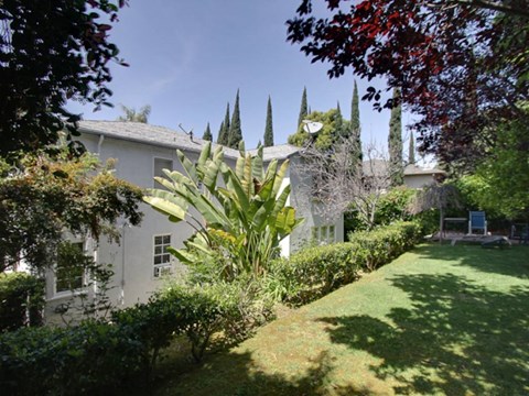 a white house with a yard and a garden