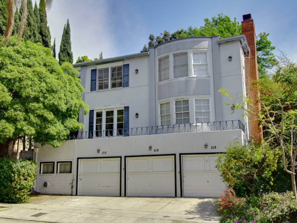the exterior of a white house with garage doors