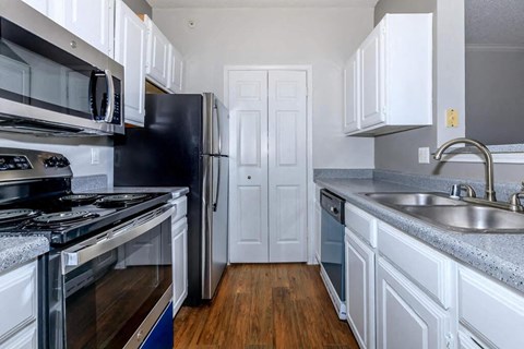 a kitchen with stainless steel appliances and white cabinets