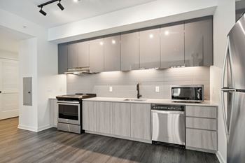 A modern kitchen with a stainless steel refrigerator and a microwave oven.