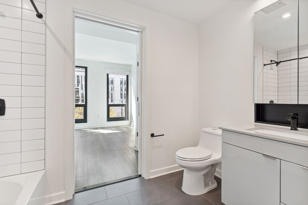 A white toilet sits next to a sink in a bathroom.