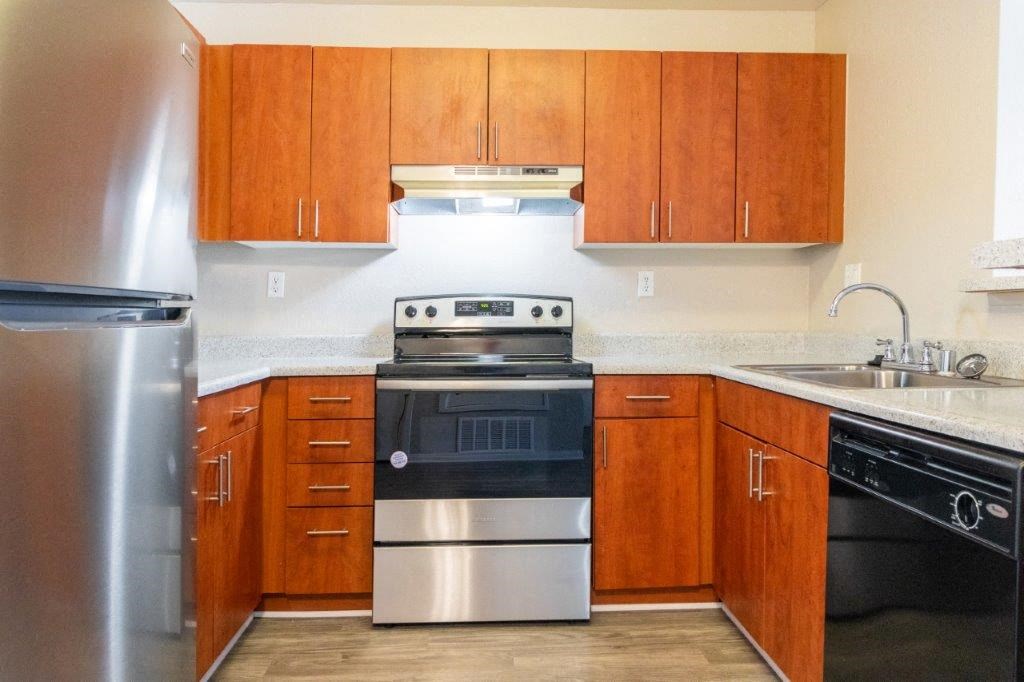 a kitchen with stainless steel appliances and wooden cabinets