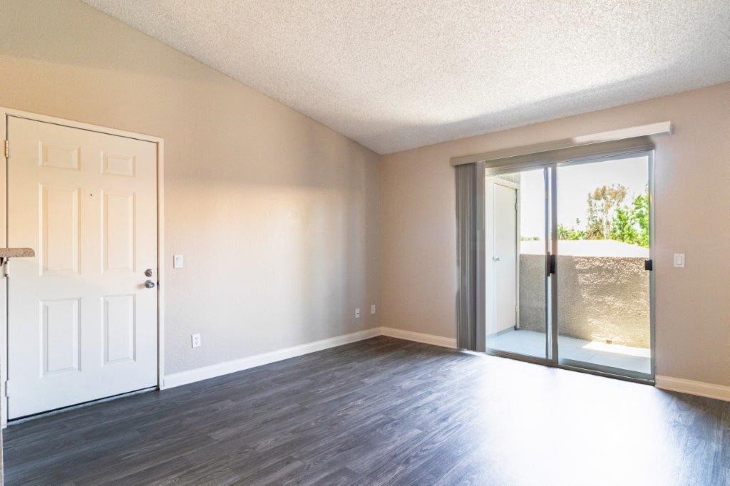 an empty living room with a door to a patio