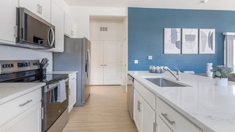A modern kitchen with stainless steel appliances and white cabinets.