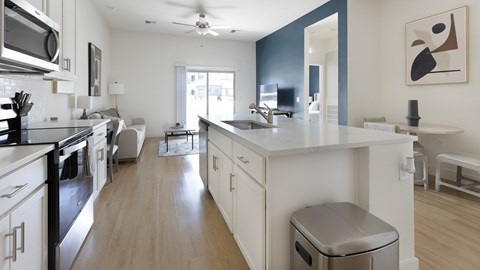 A modern kitchen with a long island and stainless steel appliances.