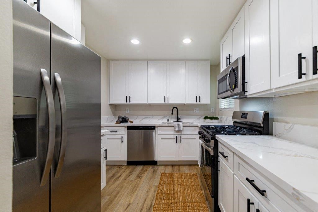a kitchen with stainless steel appliances and white cabinets