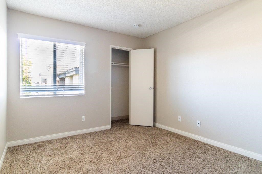 an empty room with a window and a closet
