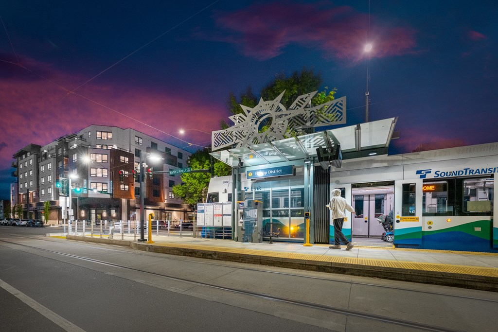 A man is waiting to board a Sound Transit train at a station.