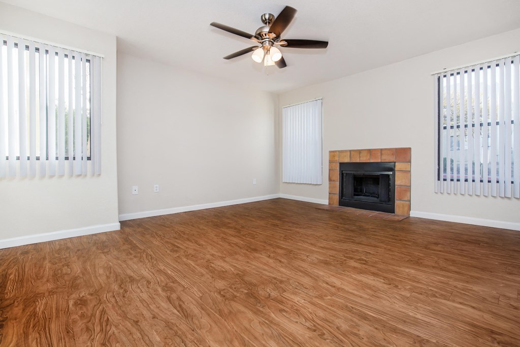 A room with a fireplace and a ceiling fan.