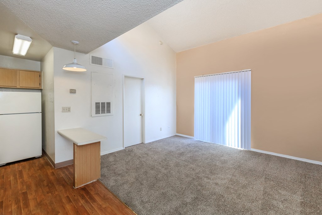 A room with a white ceiling, a white refrigerator, a white cabinet, a white counter, a white door, a white curtain, a white rug, and a white floor.