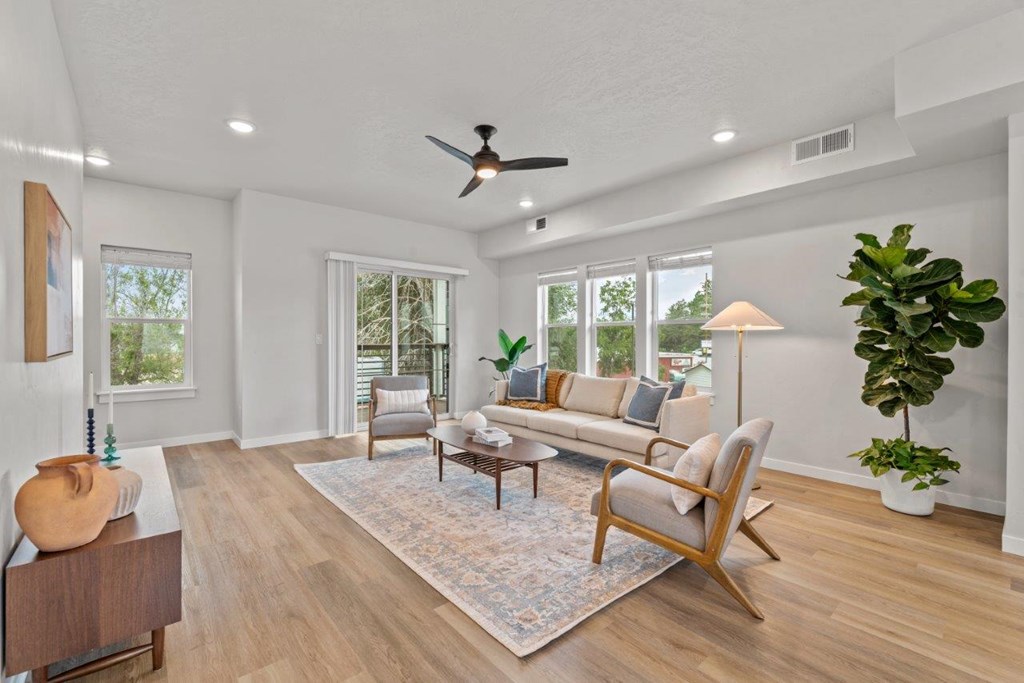 A living room with a large rug and a wooden floor.