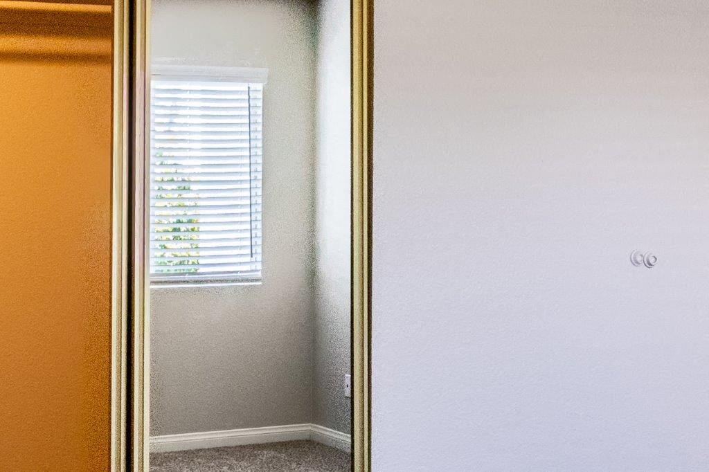 a mirror with a reflection of a window and a door