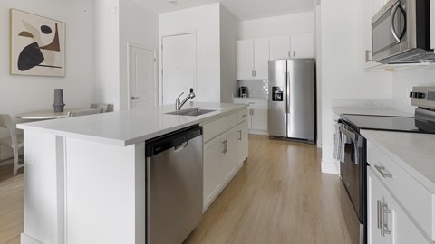A modern kitchen with white cabinets and stainless steel appliances.