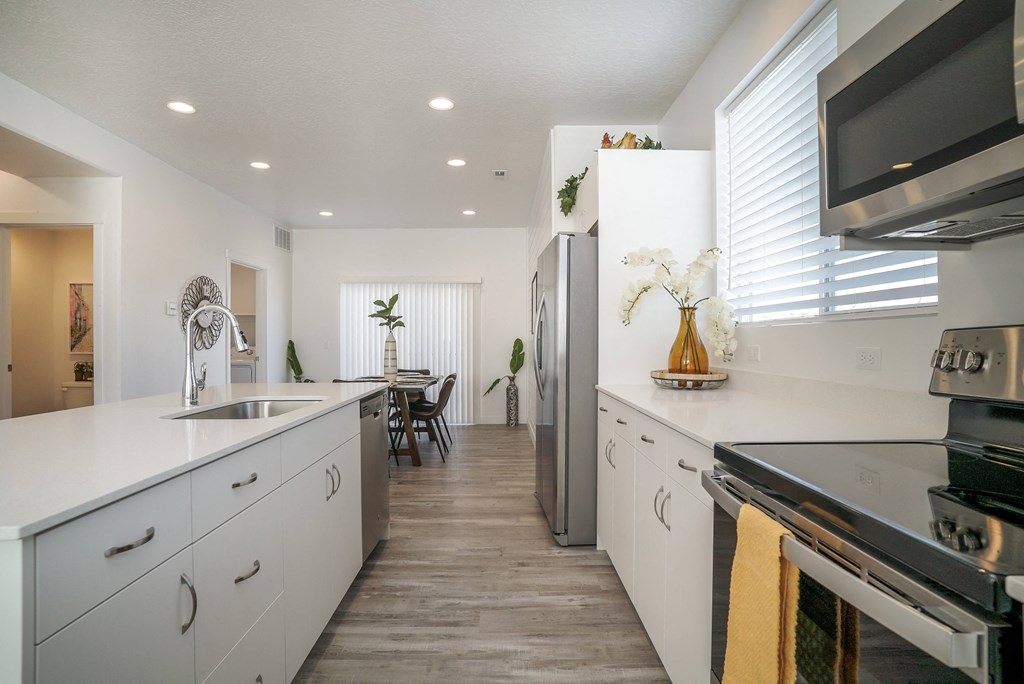 a kitchen with white cabinets and stainless steel appliances