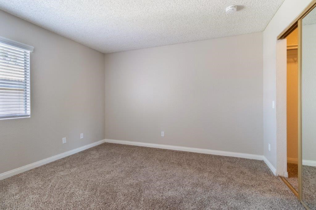 an empty room with a mirror and a carpeted floor