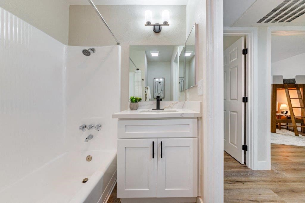 a bathroom with a sink and a tub and a mirror