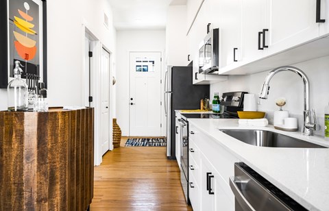 A modern kitchen with white cabinets and a wooden island.