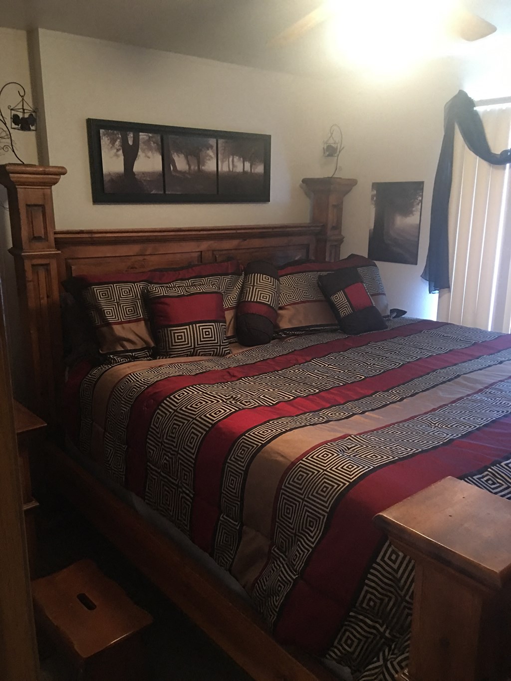 the master bedroom has a queen sized bed with many pillows