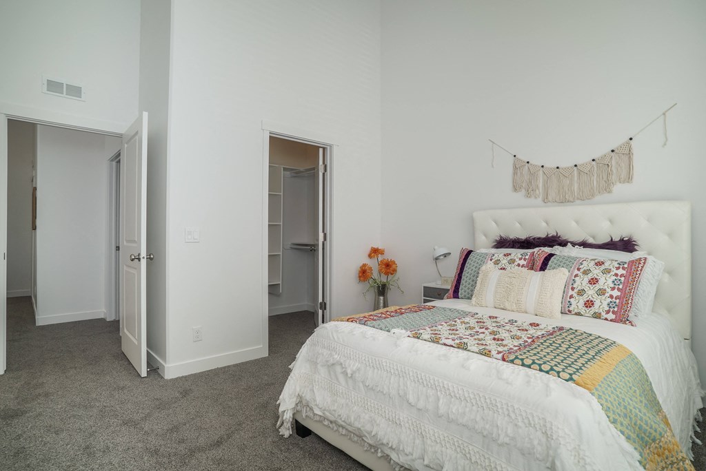 a bedroom with white walls and gray carpet