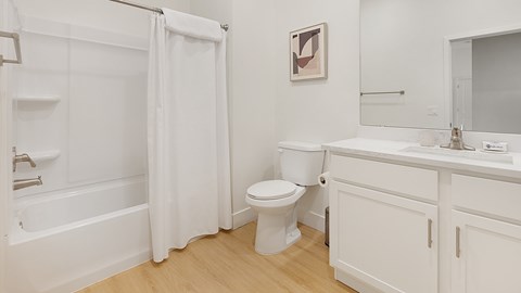 A white bathroom with a toilet, sink, and bathtub.