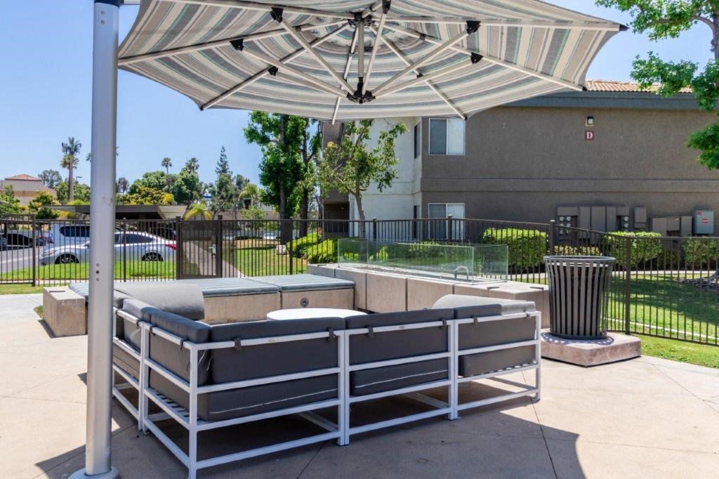 a patio with a bench and an umbrella