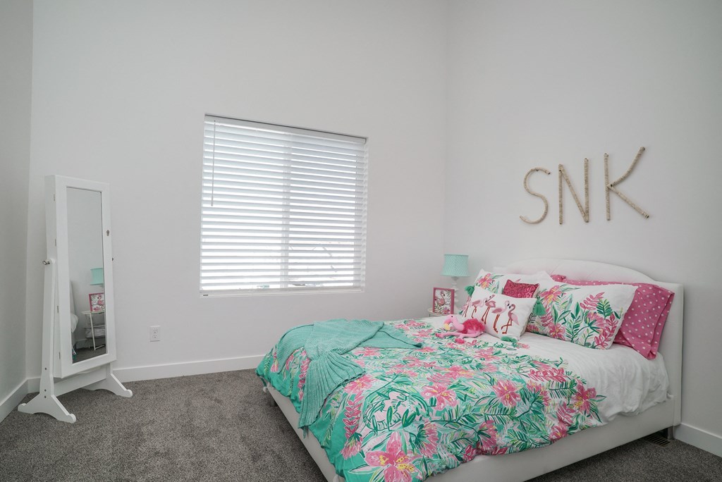 a bedroom with a bed with a tropical bedspread and pillows