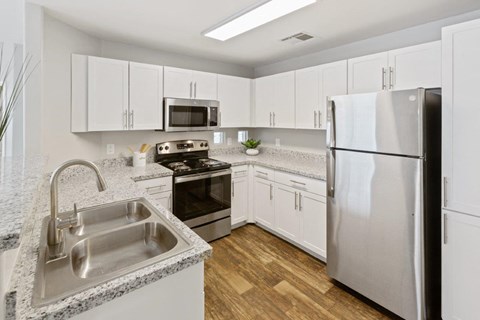 a kitchen with white cabinets and stainless steel appliances