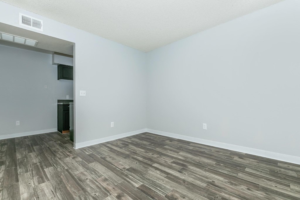 A room with a wooden floor and a white wall.