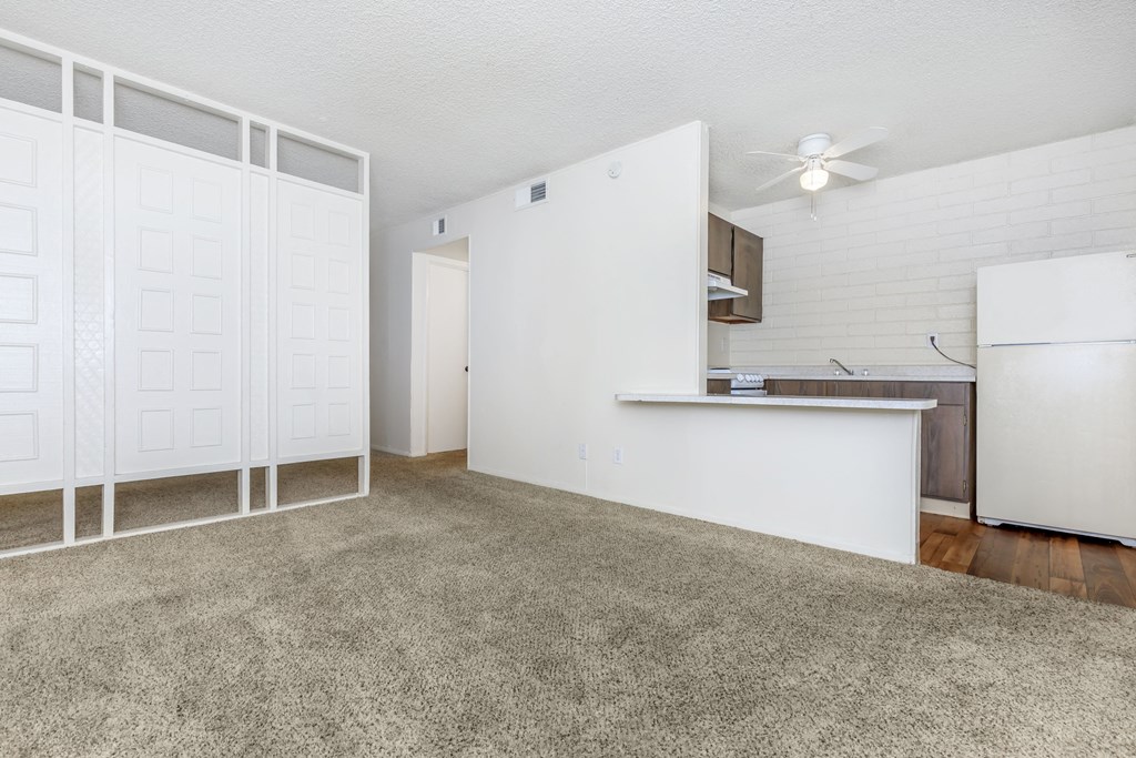 A white kitchen with a fan on the ceiling.